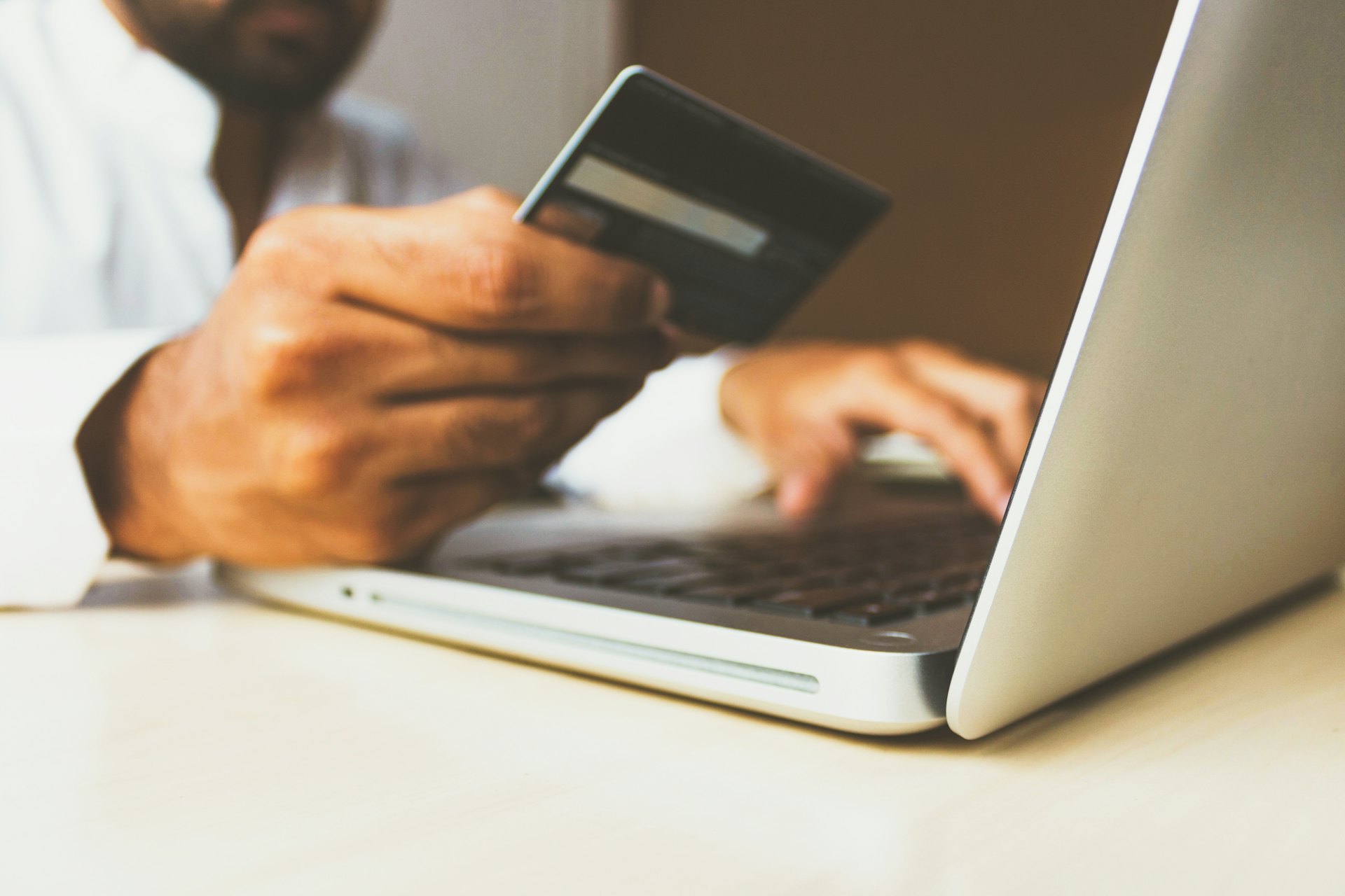 Person with card at laptop — mule bank account legal trouble India